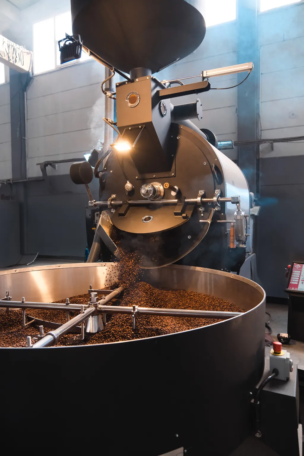 Roasted beans discharging from the drum into the cooling tray